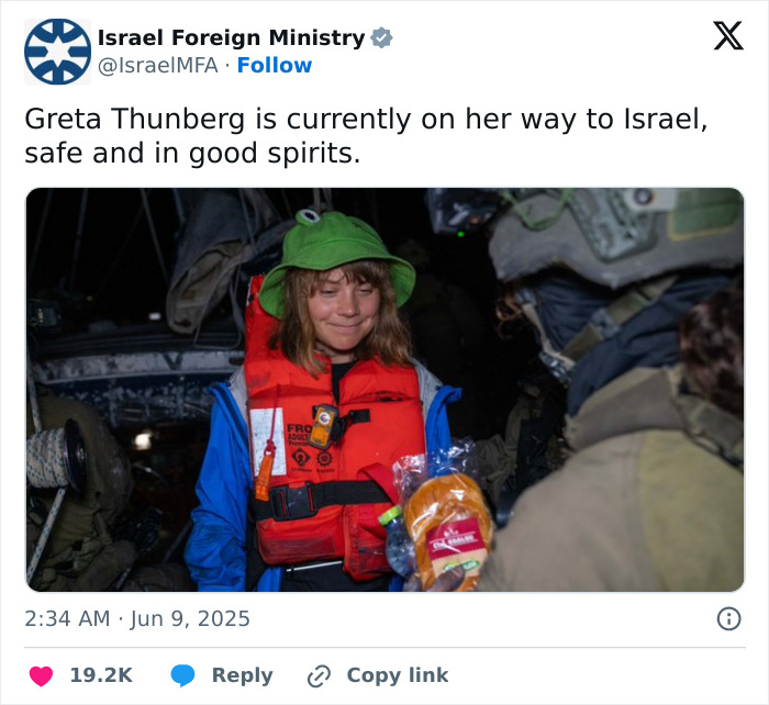 Greta Thunberg wearing life jacket and green hat aboard aid ship amid Israeli officials' alleged mistreatment claims.