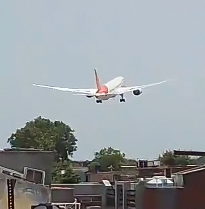 Air India airplane taking off above residential rooftops, related to the lone survivor of Air India crash story.