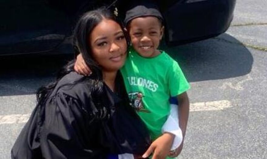 Woman smiling and hugging child outdoors, related to brain-dead pregnant woman kept alive due to Georgia abortion ban story.