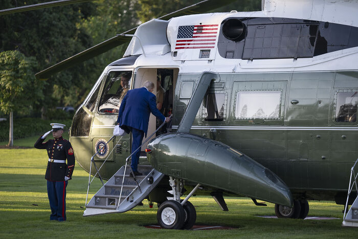 Person boarding a U.S. military helicopter with an American flag, linked to early reports on U.S. Iran strikes success doubts.