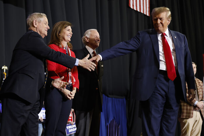 Donald Trump shaking hands with GOP supporters at a political event highlighting presidential fandom and GOP proposals.