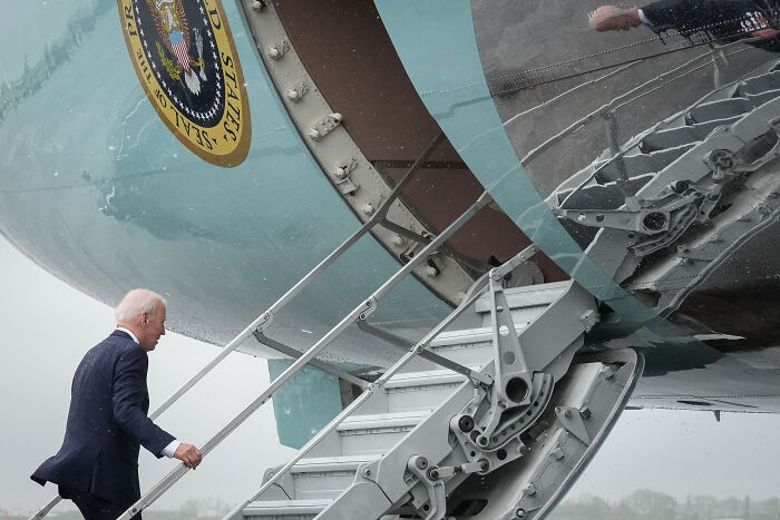 President Joe Biden ascending the Air Force One steps, contrasted with Donald Trump previously mocking Biden for tripping.