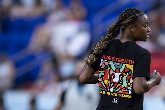 Woman wearing a Juneteenth celebrate freedom shirt, highlighting Juneteenth amid White House holiday acknowledgment controversy.