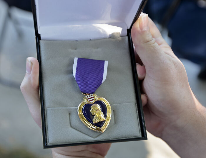 Purple Heart medal held in presentation box, symbolizing combat injury and ICE forces veteran self-deportation issues.