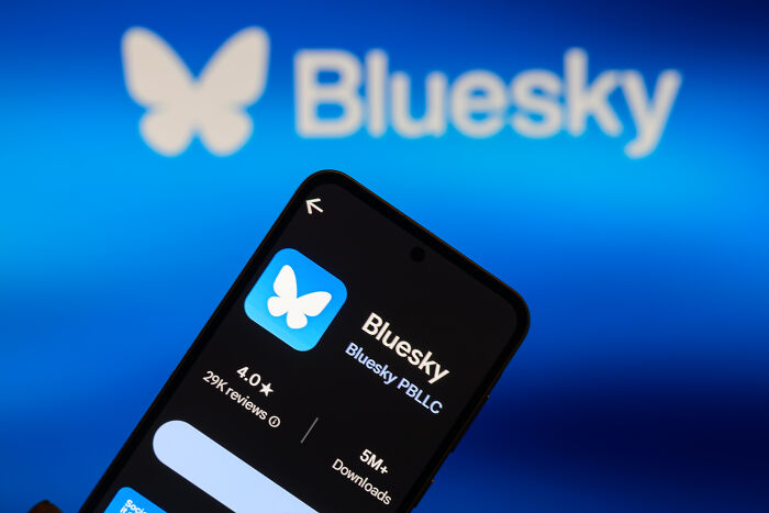 Bluesky app interface on smartphone screen with butterfly logo, highlighting Bluesky platform user suspension issue.
