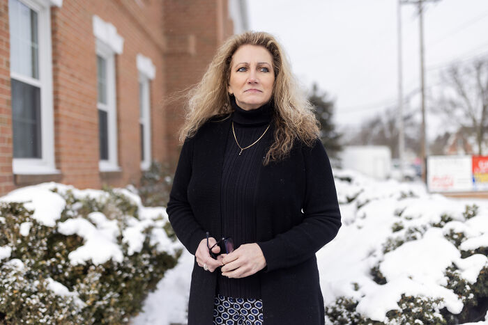 A woman stands outside in winter near a brick building, representing a Supreme Court case on reverse discrimination by gay boss.