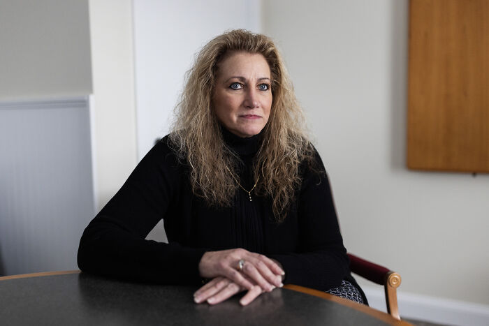 Woman with curly blonde hair in black sweater sitting at table, representing Supreme Court backing reverse discrimination claim in Ohio.
