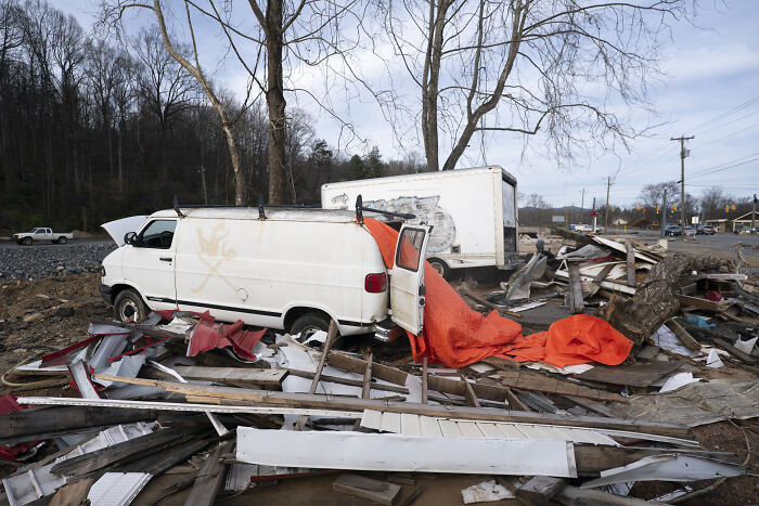 Damaged white van and debris scattered outdoors, illustrating destruction linked to hurricane season and FEMA response concerns.