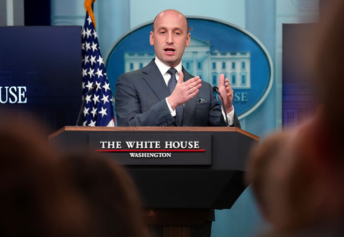 Stephen Miller speaking at The White House podium, addressing the press on political matters in Washington D.C.