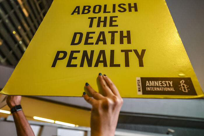 Protesters holding a yellow sign calling to abolish the death penalty amid Japan&lsquo;s execution of Twitter Killer case.