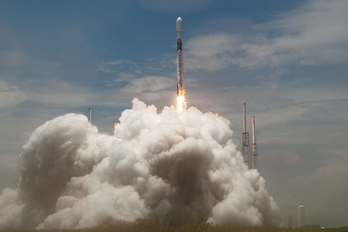 Rocket launching into the sky with smoke and fire, illustrating topics related to Elon Musk and spaceships.