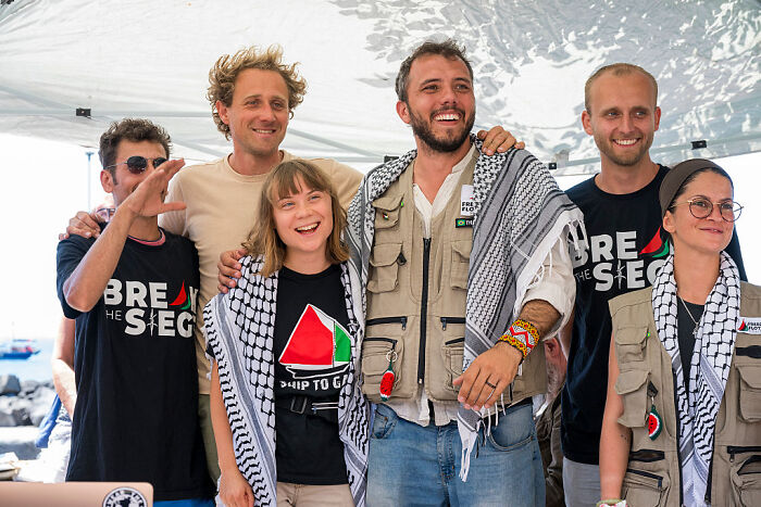 Group of activists wearing Ship to Gaza shirts and keffiyehs during Israel Gaza aid blockade protest event