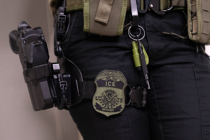 ICE officer equipped with tactical gear and badge, related to Brad Lander running for New York mayor and immigrant detention.
