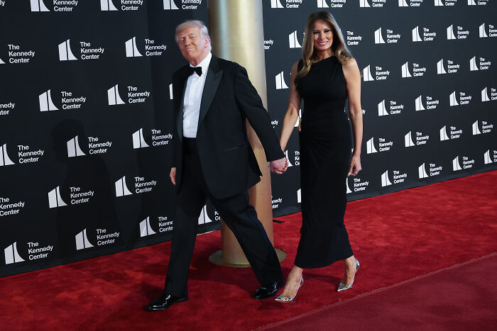 Donald and Melania Trump walking the red carpet at Les Mis&eacute;rables opening night with mixed audience boos and cheers.