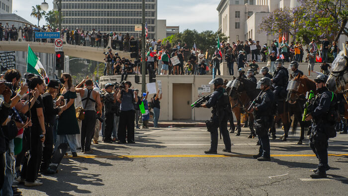 Protesters face mounted National Guard troops deployed in Los Angeles amid tensions over ICE enforcement policies.