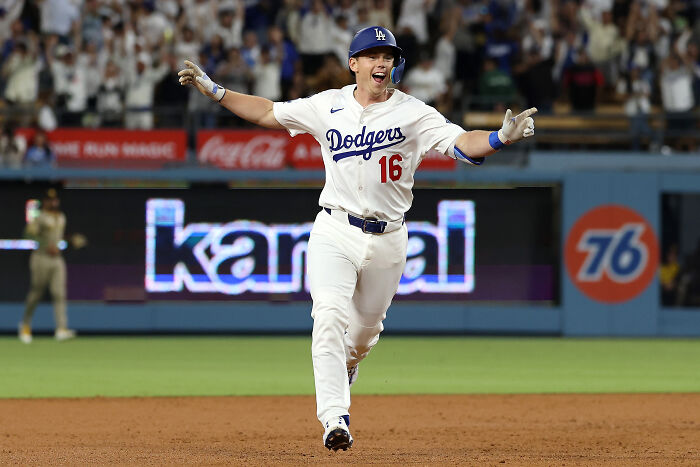 Los Angeles Dodgers player celebrating on field with crowd in the background at stadium parking lot incident.
