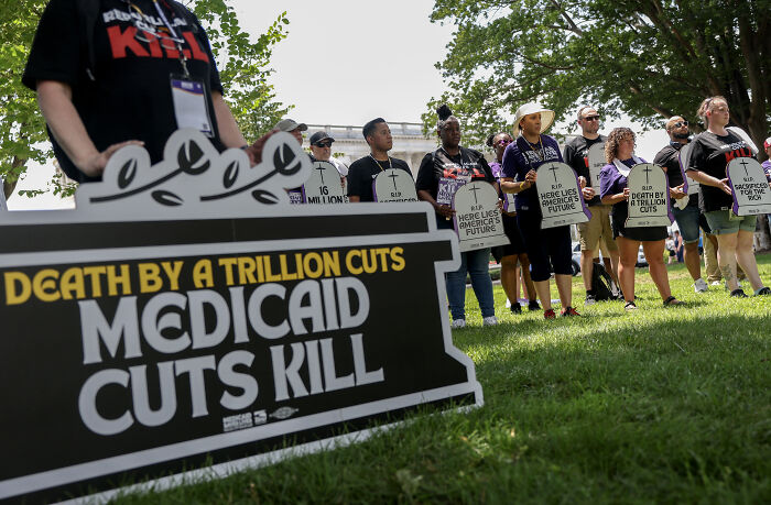 Protesters hold signs against Medicaid cuts during Senate vote-a-rama on big bill amid GOP senator's exit.