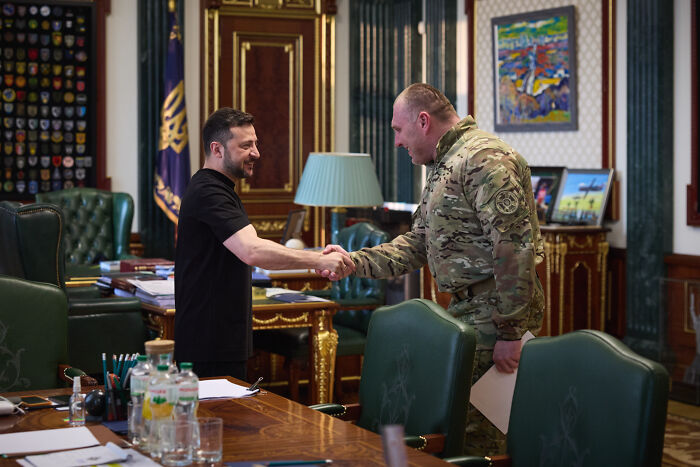 Ukrainian leader shaking hands with military officer in a formal office, highlighting potential Putin strike on NATO warning.