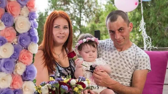 Family with young girl celebrating outdoors, highlighting the story of a girl killed in Iran missile strike after fleeing Ukraine war.