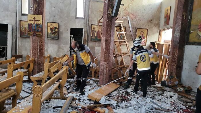 Rescue workers search through debris inside a Greek Orthodox church after a suicide bombing in Syria.