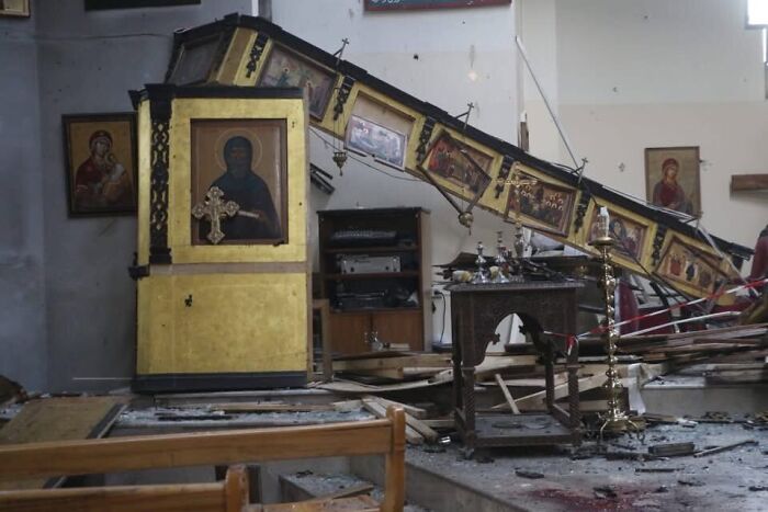 Damaged interior of Greek Orthodox Church in Syria after suicide bombing with debris and fallen religious icons.