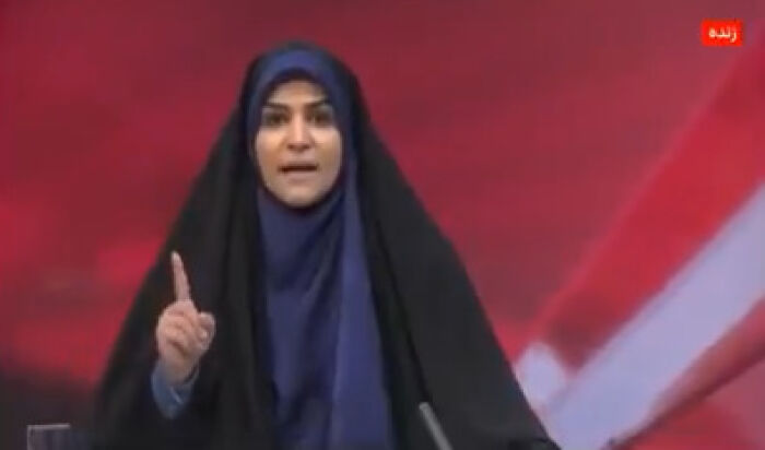 Female anchor in headscarf speaking urgently on Iran state TV moments before missile strike live on air.