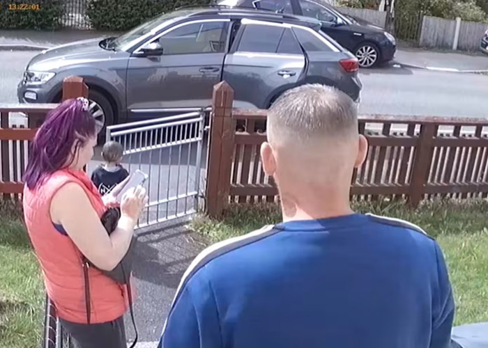 Surveillance image showing two adults and a child near a fence, related to grandparents abusing painfully thin toddler.