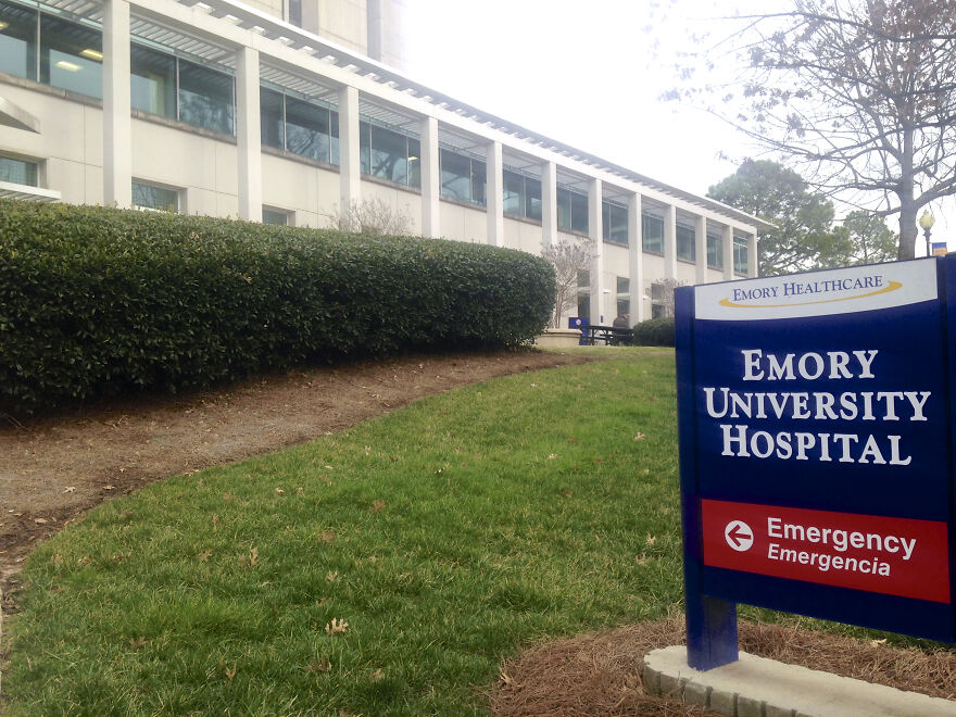 Emory University Hospital exterior with a sign, related to brain-dead pregnant woman kept alive due to Georgia abortion ban.