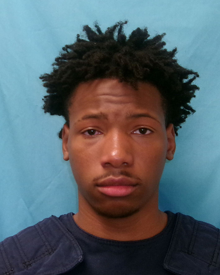 Karmelo Anthony, 17, facing charges related to a murder at a track meet stabbing incident, mugshot photo against blue background.