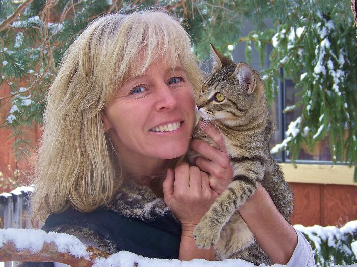 Blonde woman smiling outdoors in winter holding a tabby cat, unrelated to Nevada teacher accused of sexually abusing kids news.
