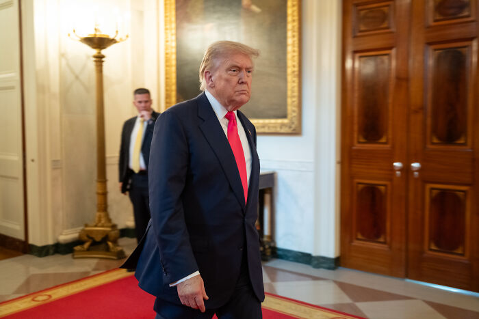Former President Donald Trump walking in a formal setting, relates to swing-vote Murkowski&rsquo;s decisive yes on GOP bill.