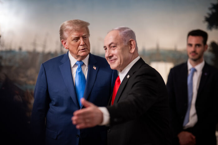 Donald Trump and Benjamin Netanyahu in a formal setting with Netanyahu gesturing during a conversation about Nobel Peace Prize nomination.