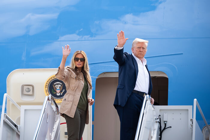 Former President Donald Trump and Melania Trump waving while boarding Air Force One, related to Barron Trump&rsquo;s U.S. citizenship debate.