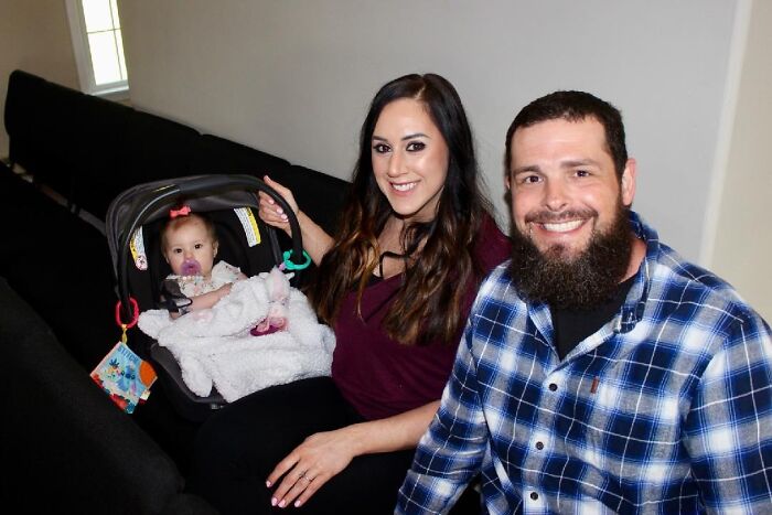 Family of Ohio mother posing indoors with baby girl, highlighting pit bull incident involving aggressive dog attack.