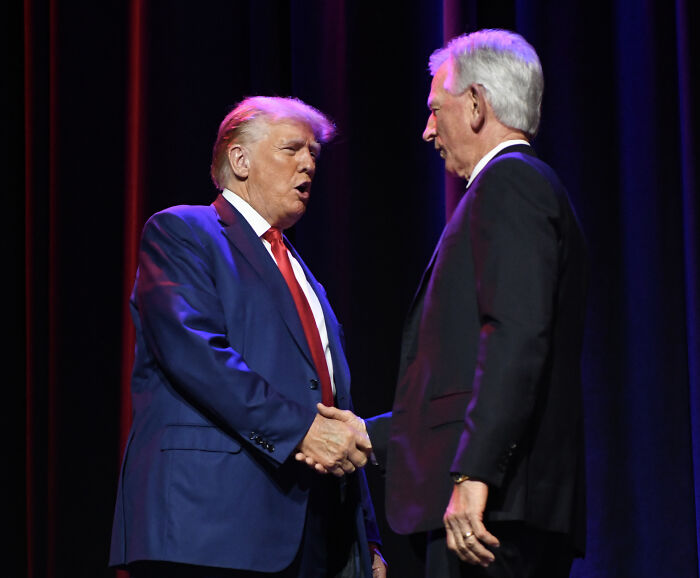 Donald Trump and GOP senator shaking hands on stage during a political event discussing Trump&rsquo;s cankles claim.