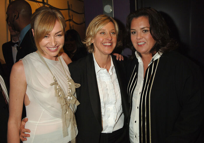 Ellen smiling and posing with Rosie O&rsquo;Donnell and a friend at an indoor event, showing support amid Trump controversy.