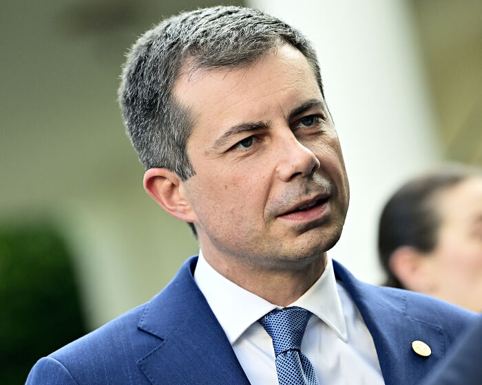 Pete Buttigieg speaking at an event, wearing a blue suit and tie, leading 2028 Democratic primary poll.