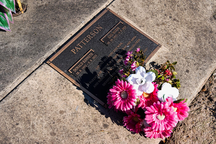 Gravestone plaque with Patterson family name and flowers, reflecting mushroom poisoning case and guilty verdict.