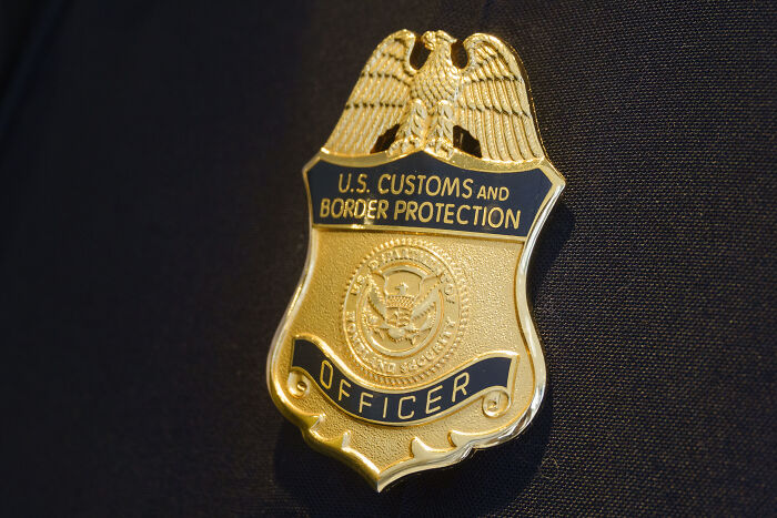 Close-up of U.S. Customs and Border Protection officer badge representing immigration sanctuary laws enforcement efforts.