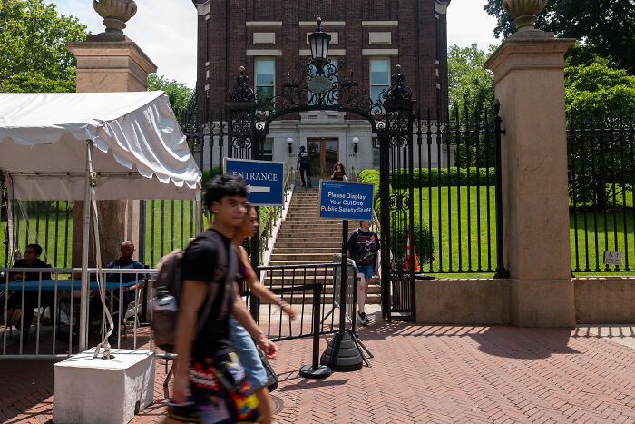 Students walking past a gated entrance at Columbia University amid Zohran Mamdani SAT scores and application controversy.