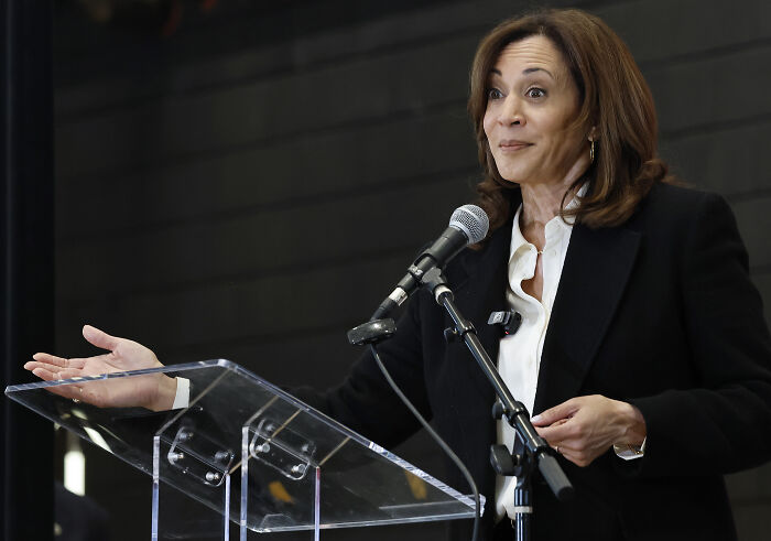 A woman speaking at a podium with a microphone, representing the impact of the 2024 presidential election on young Americans&rsquo; mental health.