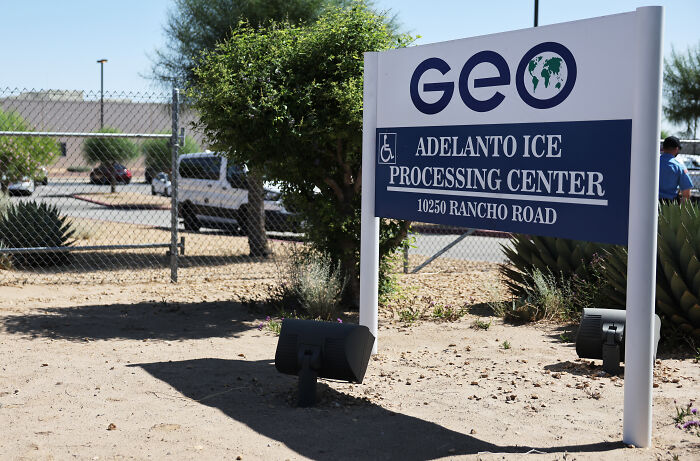Sign at Adelanto ICE Processing Center, highlighting Iranian MAGA supporter held in ICE prison related to Donald Trump remarks.
