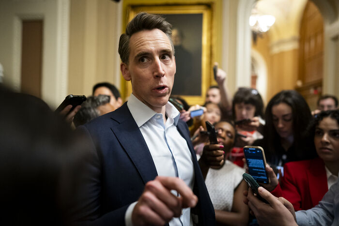 Josh Hawley speaking to reporters in a hallway, addressing Medicaid cuts he recently helped pass and aims to reverse.