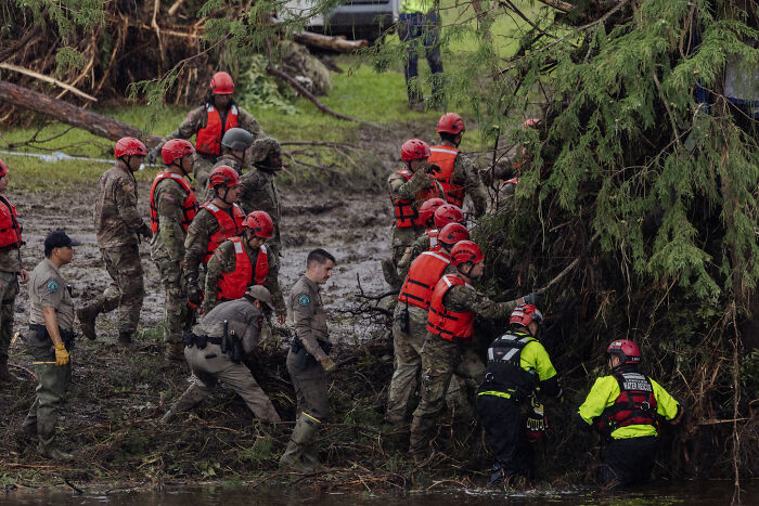 Rescue team wearing life vests and helmets working in flood waters in Texas amid rising flood crisis.