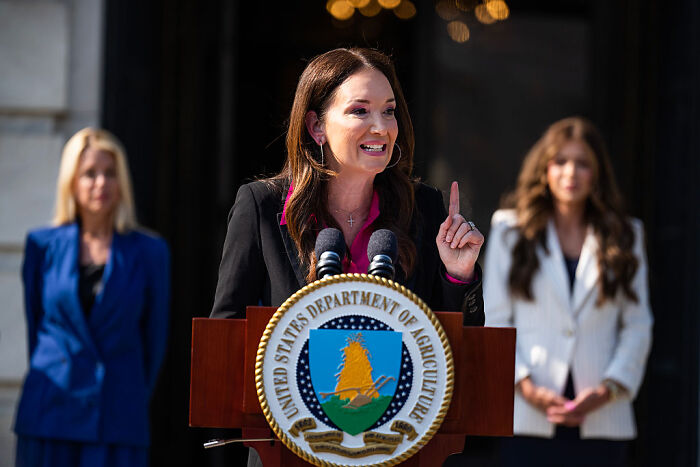 Agriculture Secretary speaking at podium, addressing Medicaid recipients and farmworker workforce replacement.