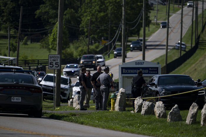 Police gather near a church and road with multiple vehicles after shootings near Kentucky airport and church incidents.