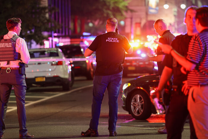 Police officers and state police respond at night near the scene of the New York shooter rampage incident.