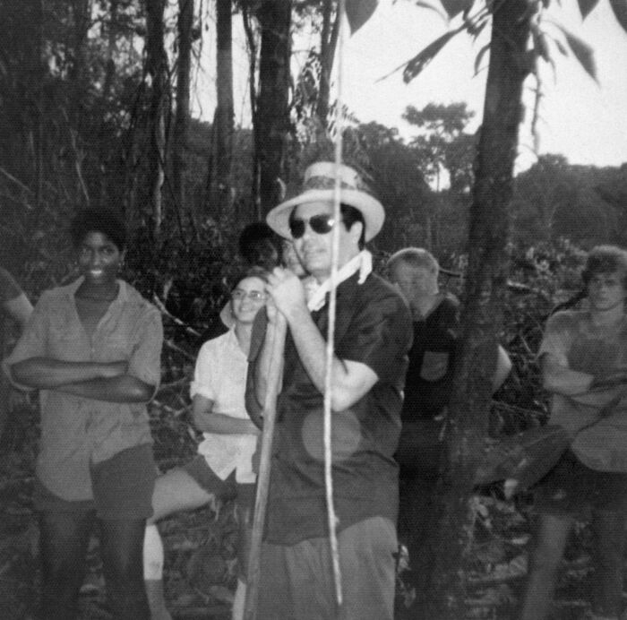 Black and white photo of people in a wooded area, related to survivors who escaped Jonestown as a tourist destination.