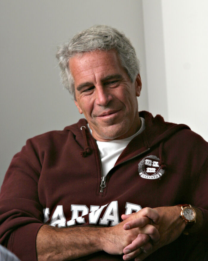 Man in a Harvard sweatshirt sitting with hands clasped, related to Trump senior advisor confirming Epstein client list video.