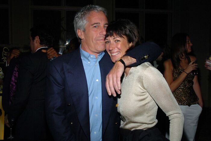 Jeffrey Epstein and Ghislaine Maxwell posing closely at a social event with people in the background.